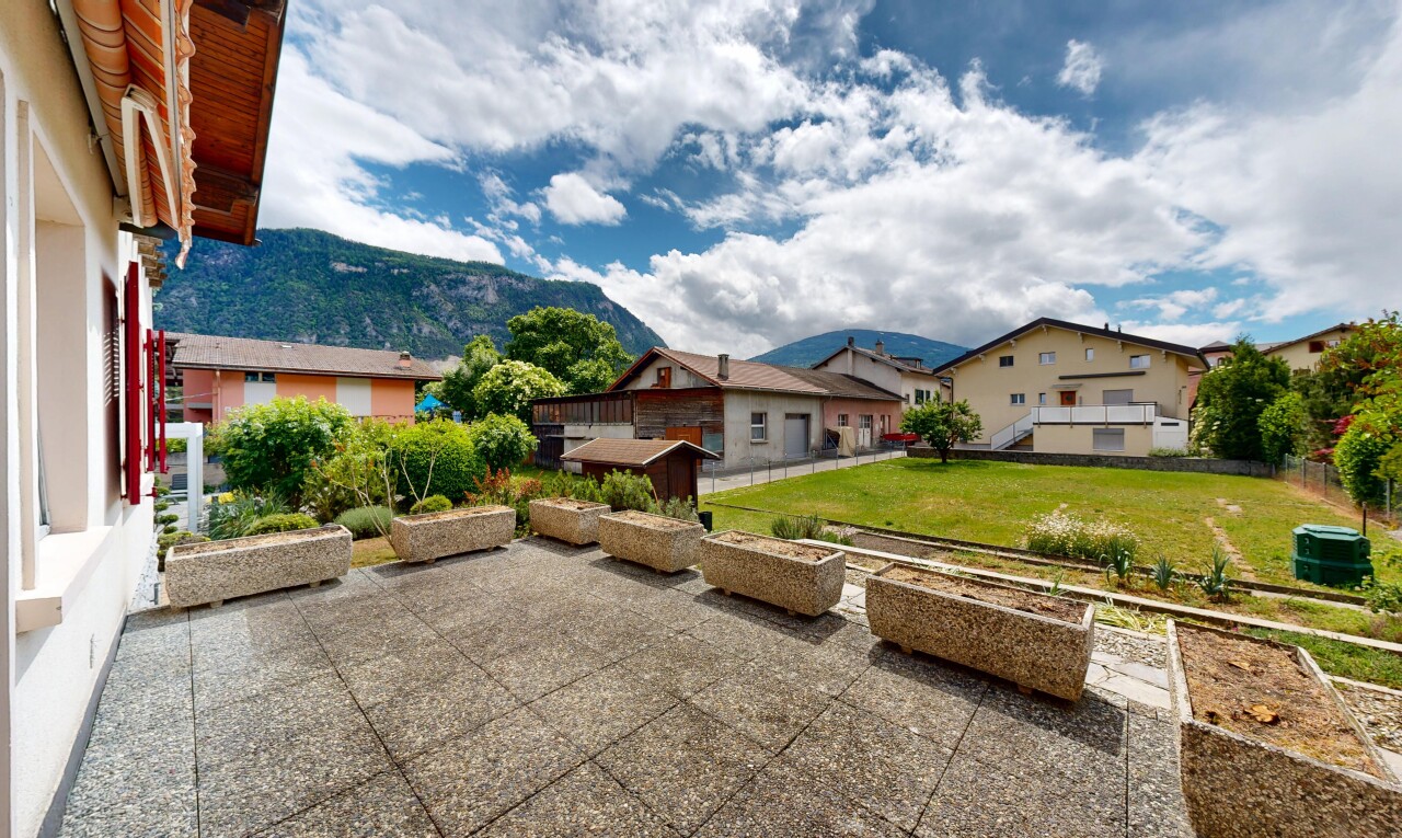 outdoor house featuring a yard, a mountain view, and a garden