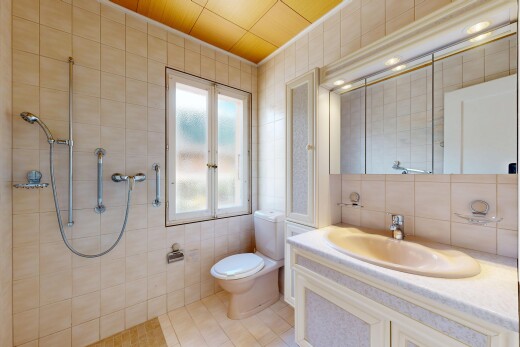 salle de bains avec mur en carrelage, tile wall, lavabo (ou coiffeuse selon le contexte), toilette, et salle de bain complète