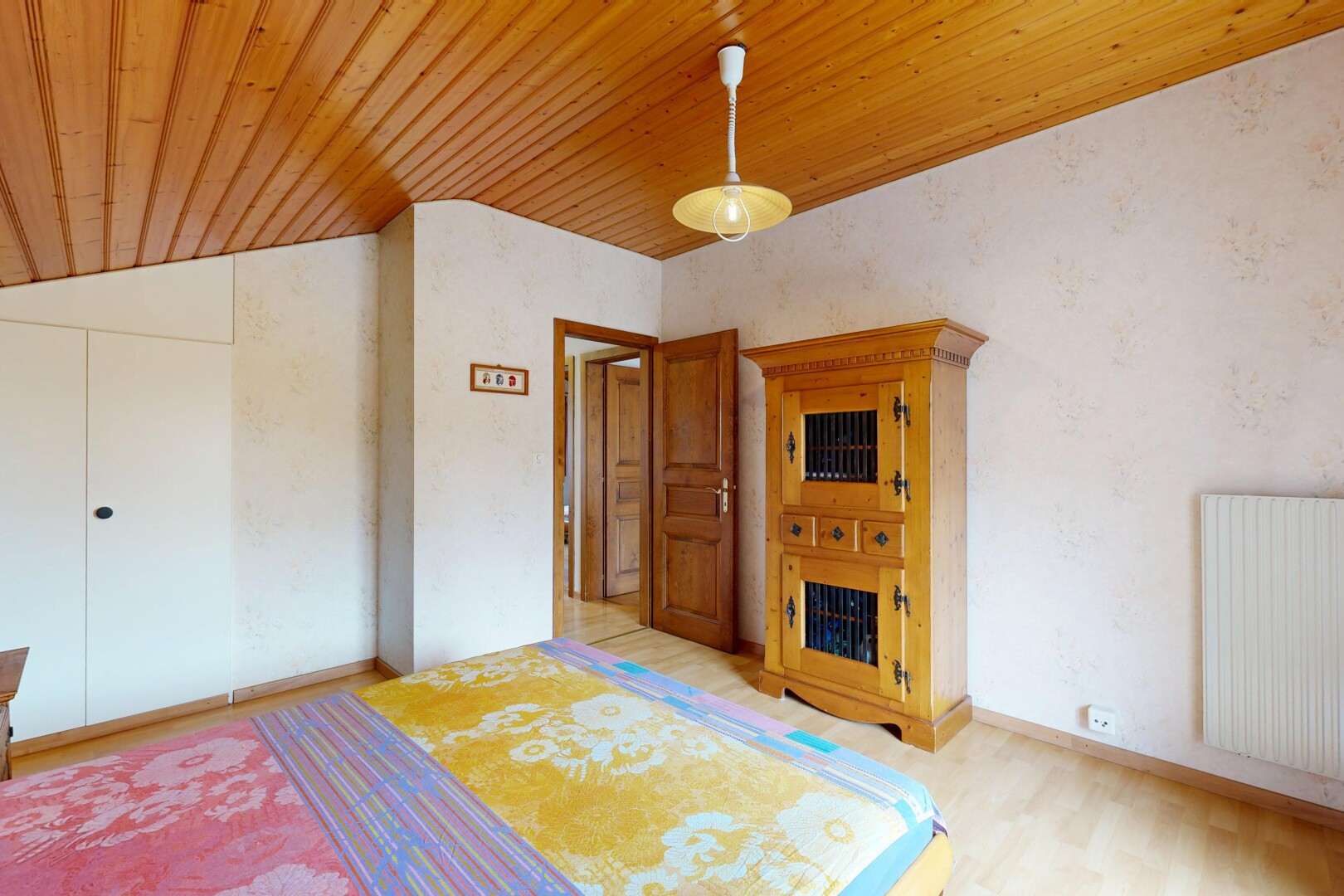 chambre avec éclairage suspendu, radiateur, wood ceiling, plafond en bois, et vaulted ceiling