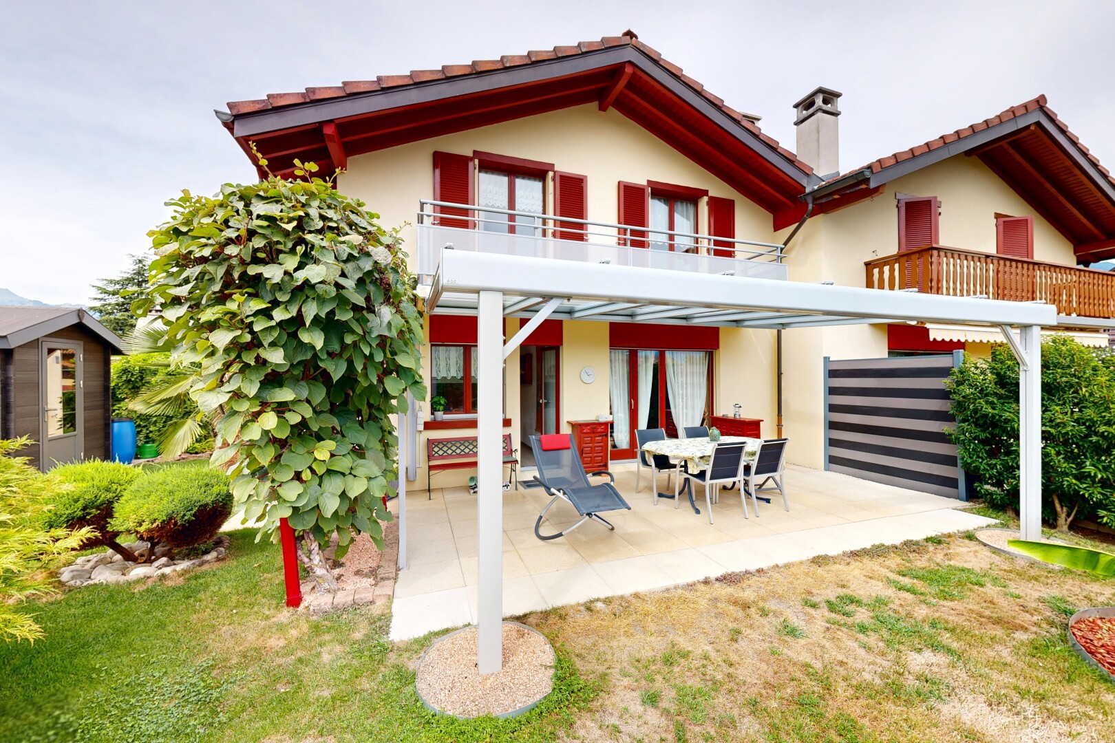 façade avec terrasse, cheminée, property visible, toit en tuiles, et balcon