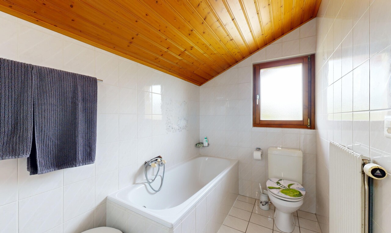 salle de bains avec toilette, tile wall, mur en carrelage, salle de bain complète, et bain