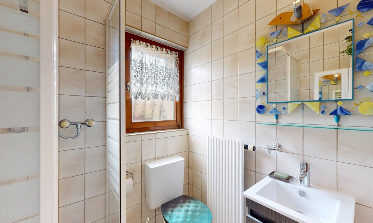 salle de bains avec salle de bain complète, douche, radiateur, toilette, et tile wall