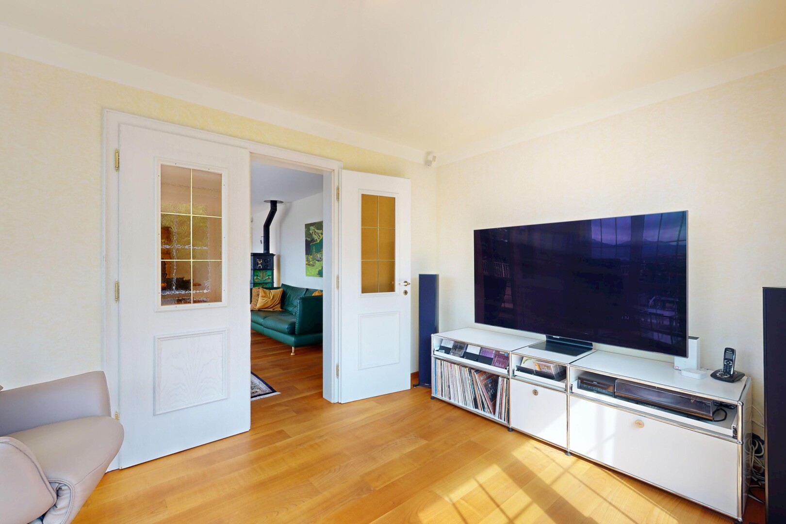 wohnzimmer mit fernseher, wood finish floor, holzfußboden, drywall, und gipskartonwand