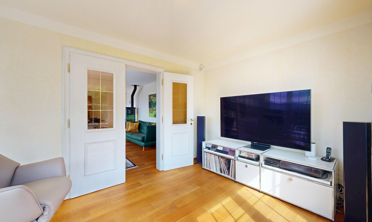 wohnzimmer mit fernseher, wood finish floor, holzfußboden, drywall, und gipskartonwand
