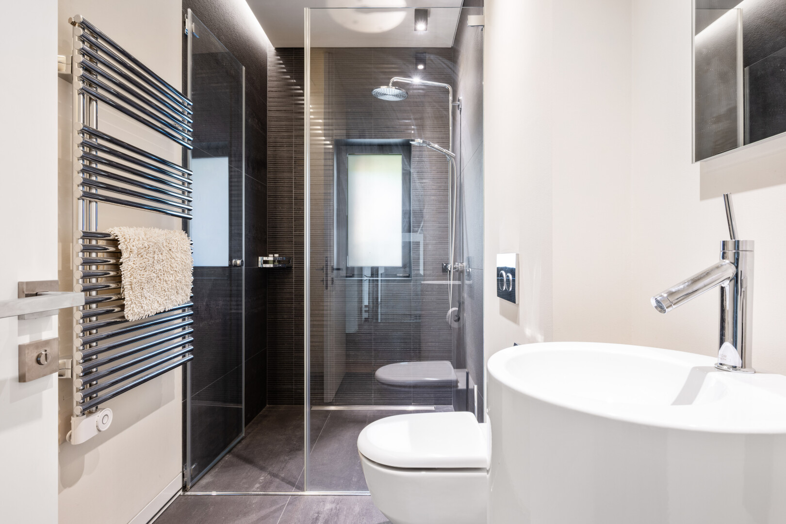 salle de bains avec chauffe-serviettes, radiateur, douche, salle de bain complète, et miroir