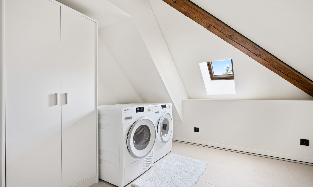 buanderie avec puits de lumière, light floor, cloison sèche, drywall, et inside property