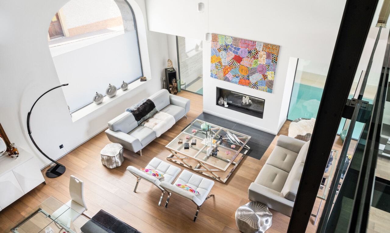 salon avec sol en finition bois, wood finish floor, inside property, plafond haut, et high ceiling