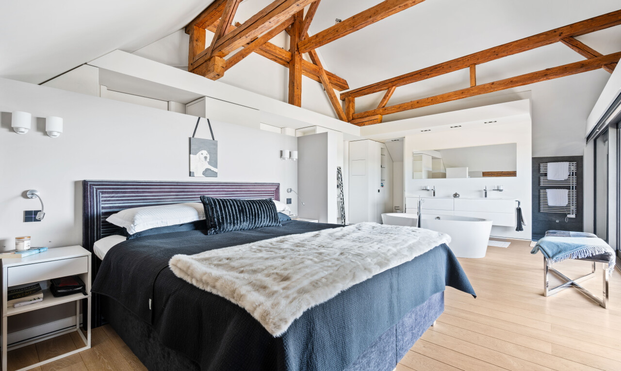 chambre avec wood finish floor, sol en finition bois, inside property, light floor, et high ceiling