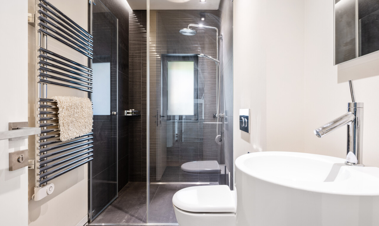 salle de bains avec chauffe-serviettes, radiateur, douche, salle de bain complète, et miroir