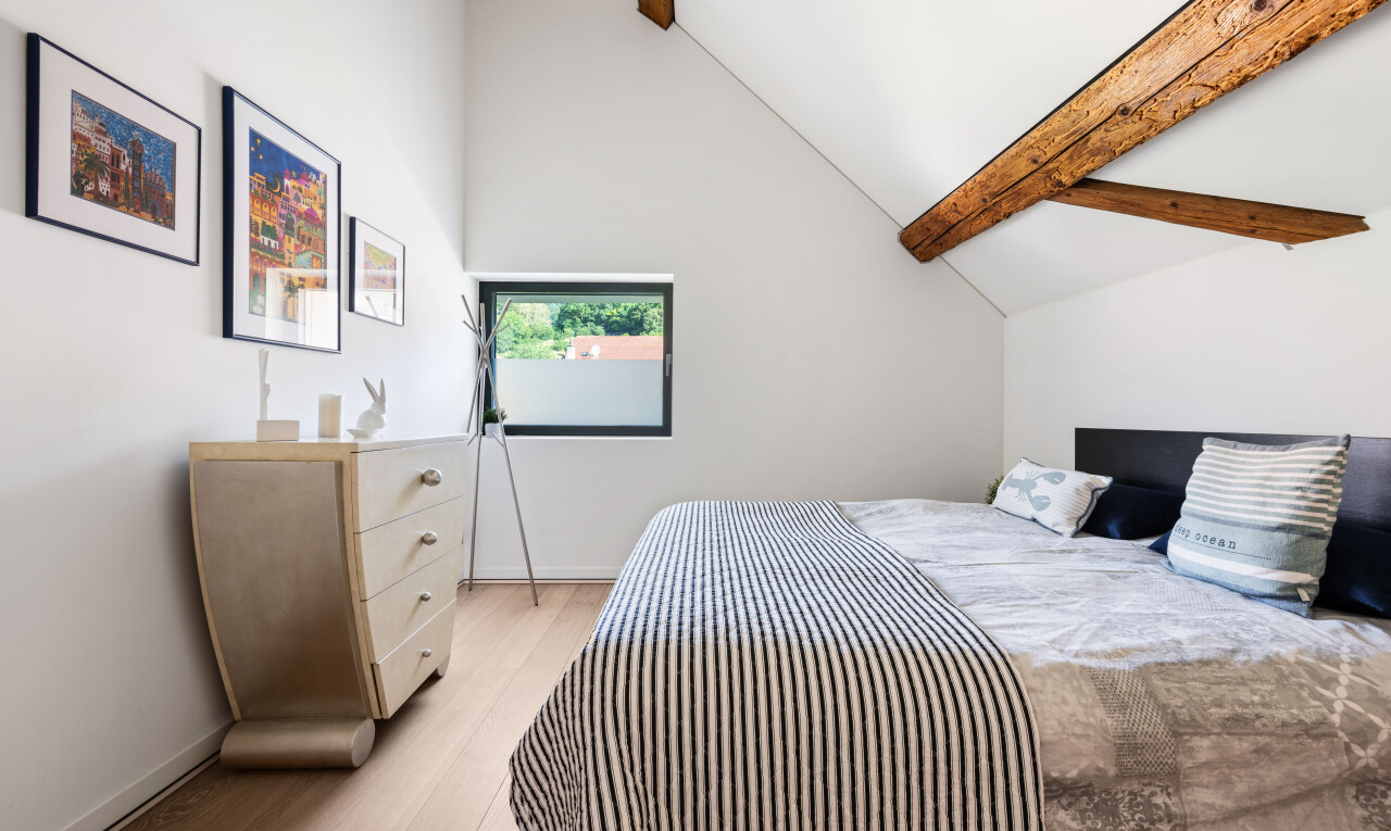 chambre avec plafond à poutres, beamed ceiling, cloison sèche, drywall, et sol en finition bois