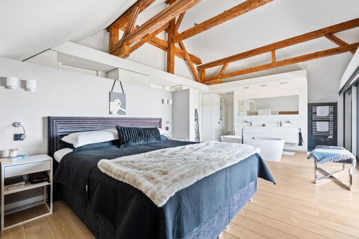 chambre avec wood finish floor, sol en finition bois, inside property, light floor, et high ceiling
