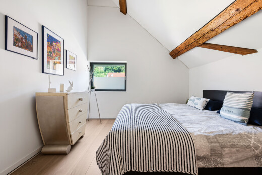 chambre avec plafond à poutres, beamed ceiling, cloison sèche, drywall, et sol en finition bois