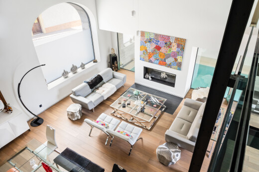 salon avec sol en finition bois, wood finish floor, inside property, plafond haut, et high ceiling