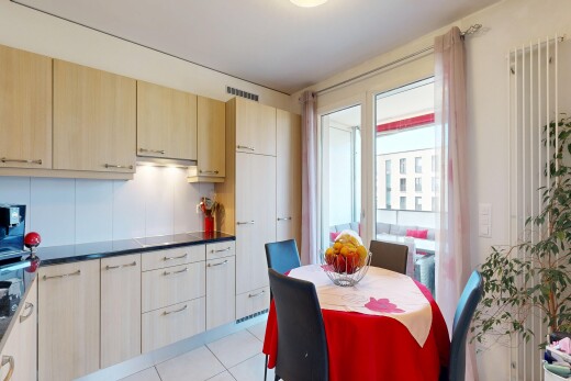 cuisine avec plans de travail, dark countertops, light floor, armoires marron clair, et light brown cabinets