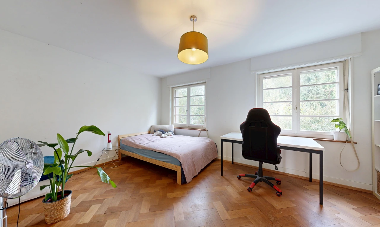 chambre avec éclairage suspendu, drywall, cloison sèche, lumière naturelle, et wood finish floor