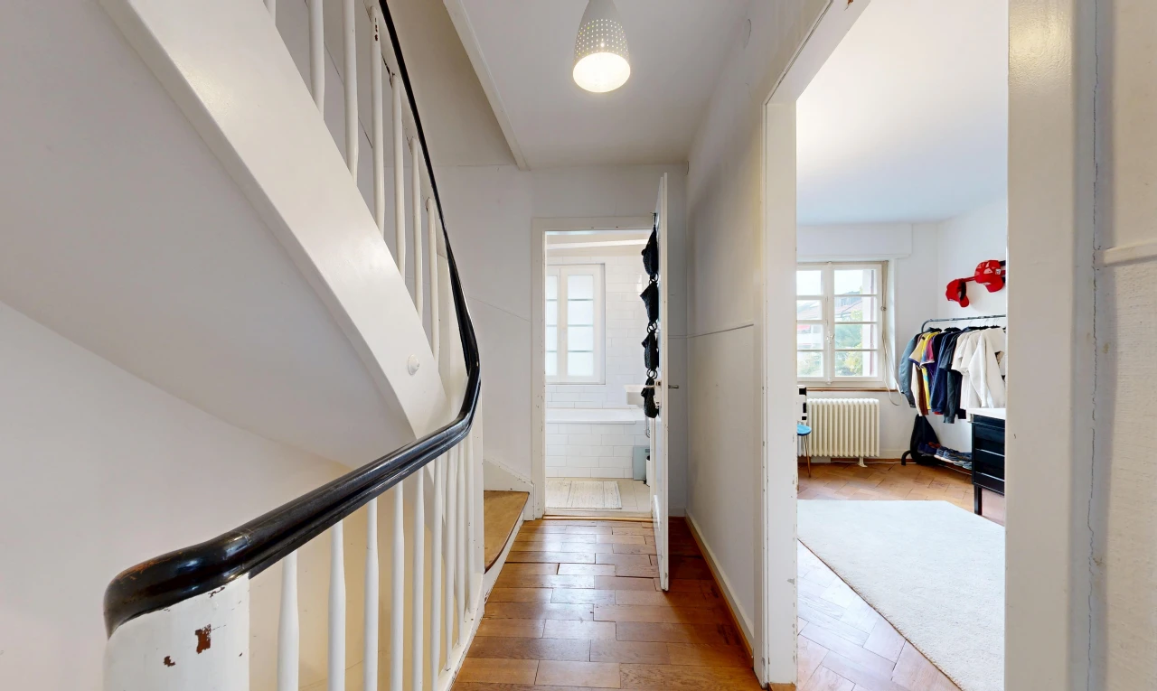 couloir avec radiateur, wood finish floor, sol en finition bois, drywall, et cloison sèche