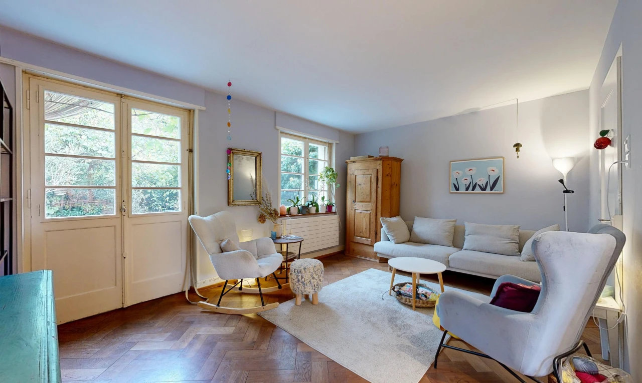 salon avec wood finish floor, sol en finition bois, drywall, cloison sèche, et parquet floor