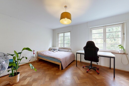 chambre avec éclairage suspendu, drywall, cloison sèche, lumière naturelle, et wood finish floor