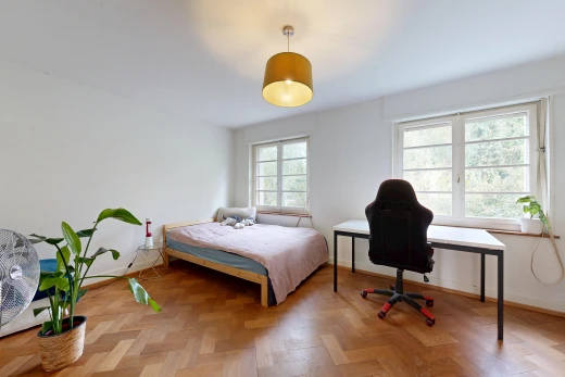 chambre avec éclairage suspendu, drywall, cloison sèche, lumière naturelle, et wood finish floor