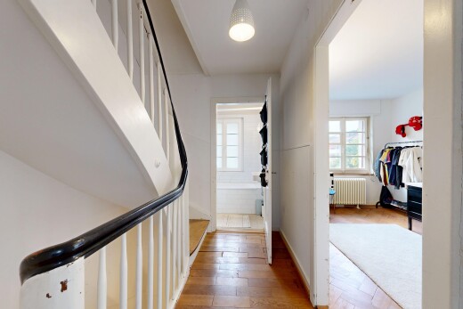 couloir avec radiateur, wood finish floor, sol en finition bois, drywall, et cloison sèche