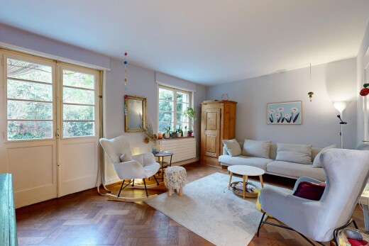 salon avec wood finish floor, sol en finition bois, drywall, cloison sèche, et parquet floor