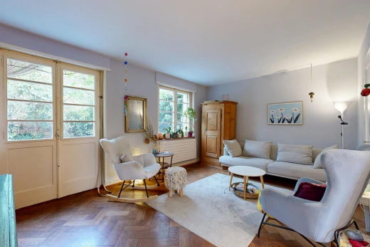 salon avec wood finish floor, sol en finition bois, drywall, cloison sèche, et parquet floor