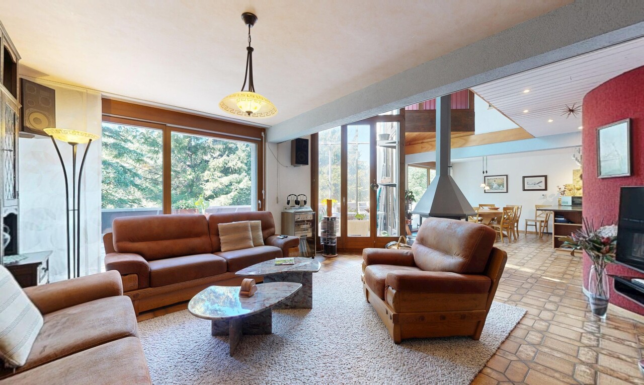 salon avec éclairage suspendu, poêle à bois, inside property, et éclairage encastré