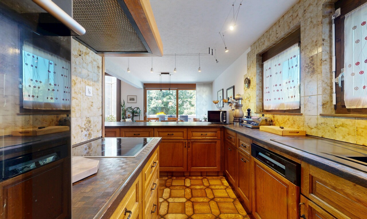 cuisine avec éclairage sur rail, dark countertops, plans de travail, hotte, et lave-vaisselle