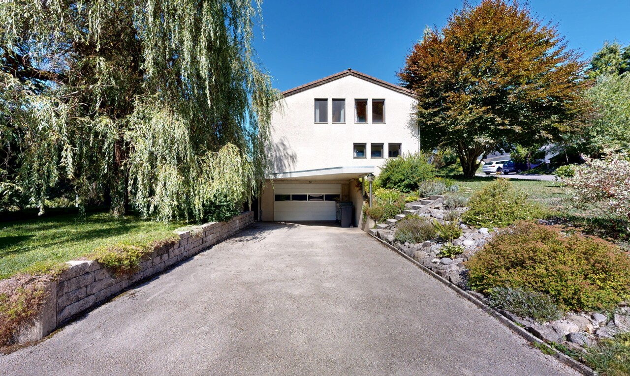 façade avec property visible, allée, garage intégré, bardage en stuc, et garage au sous-sol