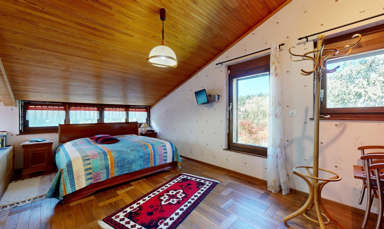 chambre avec vaulted ceiling, plafond voûté, wood finish floor, sol en finition bois, et éclairage suspendu