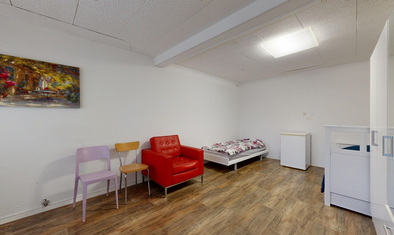 zimmer / schlafzimmer mit inside property, kühlschrank, wood finish floor, holzfußboden, und drywall