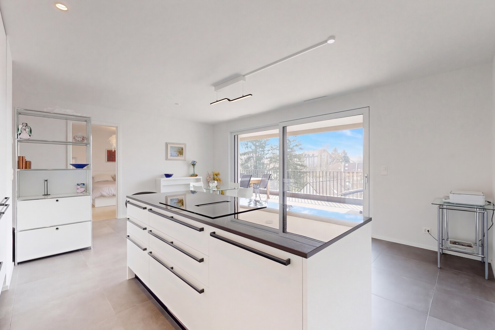 kitchen featuring modern cabinets, a kitchen island, white cabinetry, black electric stovetop, and dark countertops