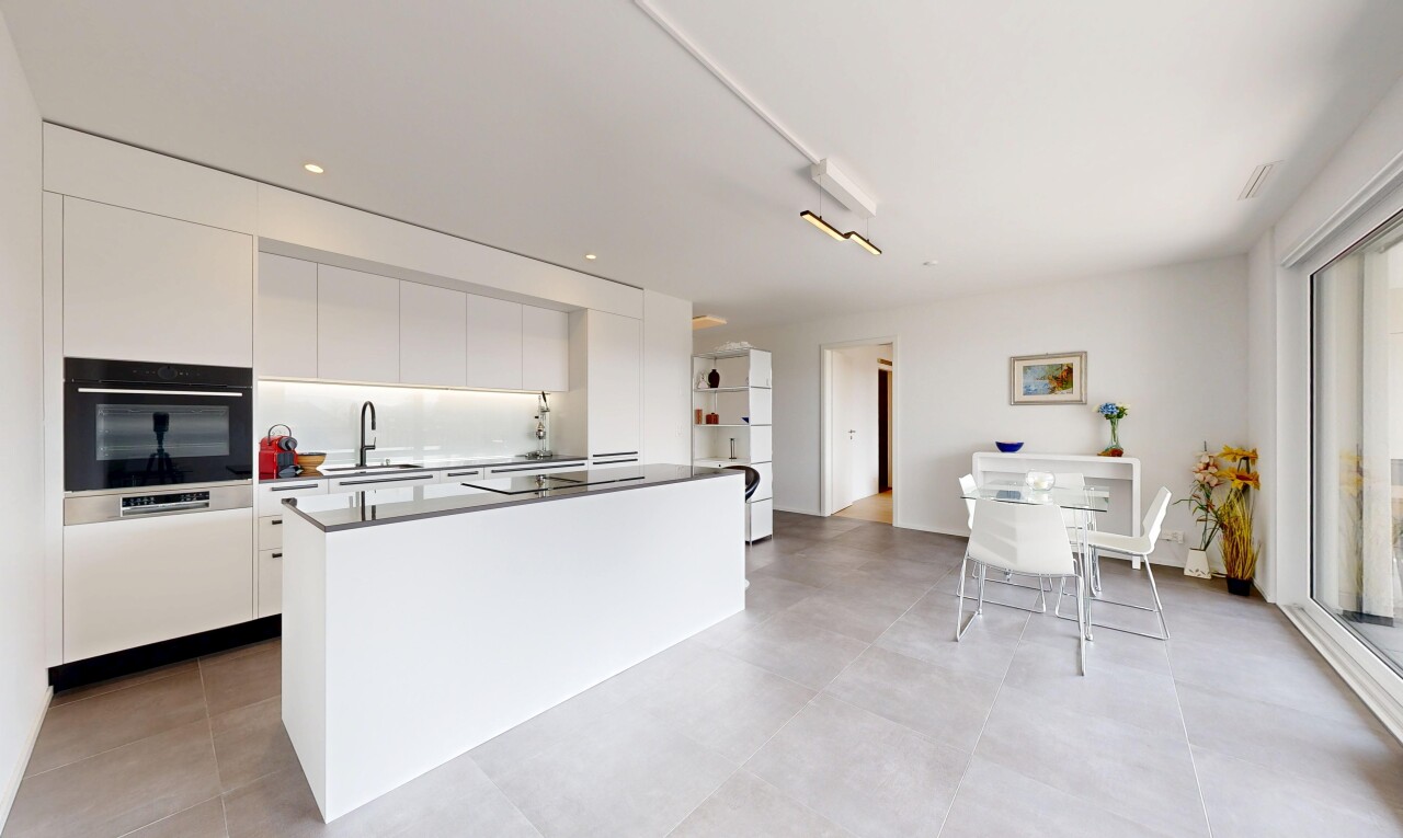 kitchen featuring black appliances, a center island, modern cabinets, white cabinetry, and dark countertops
