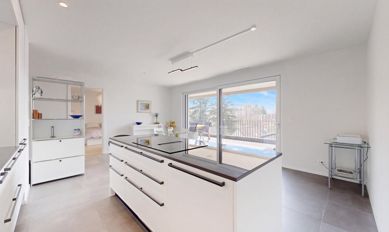 kitchen featuring modern cabinets, a kitchen island, white cabinetry, black electric stovetop, and dark countertops