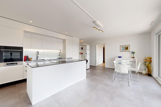 kitchen featuring black appliances, a center island, modern cabinets, white cabinetry, and dark countertops