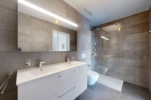 full bathroom featuring tile walls, walk in shower, double vanity, and tile patterned floors