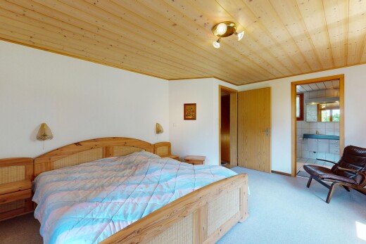 room / bedroom featuring wood ceiling, light colored carpet, and ensuite bath