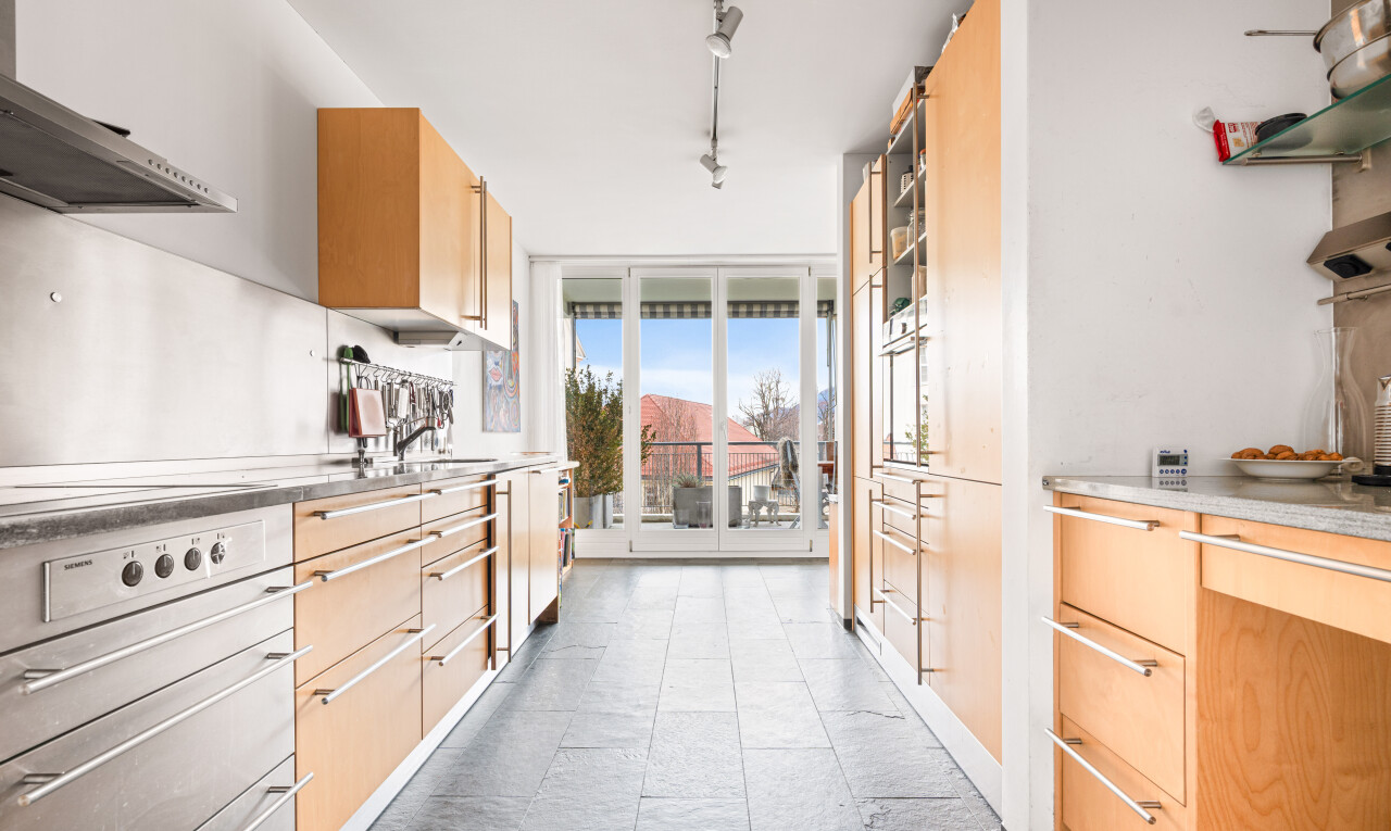 cuisine avec day time, hotte, armoires marron clair, light brown cabinets, et inside property