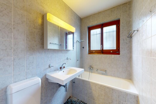 bathroom featuring tile walls and toilet