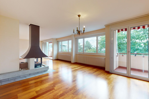 leerer raum mit natürliches licht, kühler, kamin, bemerkenswerter kronleuchter, und parkettboden