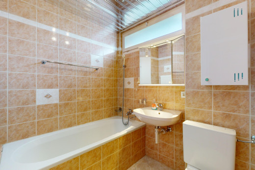 bad mit spiegel, fliesenwand, toilette, kombiniertes bad / dusche, und waschbecken