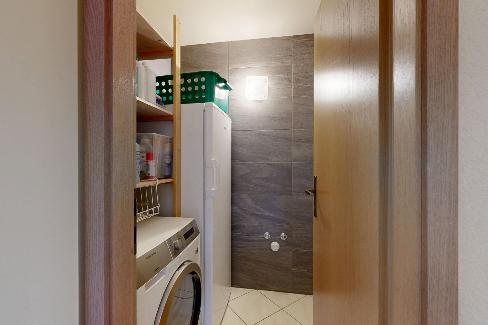 laundry room with washer / dryer, light tile patterned floors, and tile walls