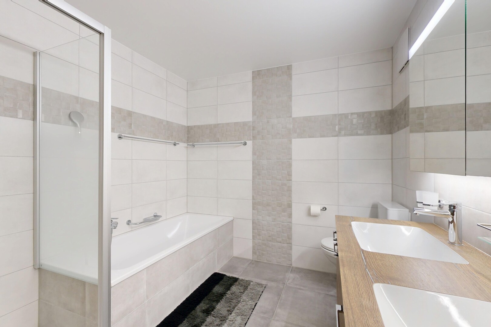 full bathroom with tile walls, a bath, double vanity, tiled shower, and tile patterned floors