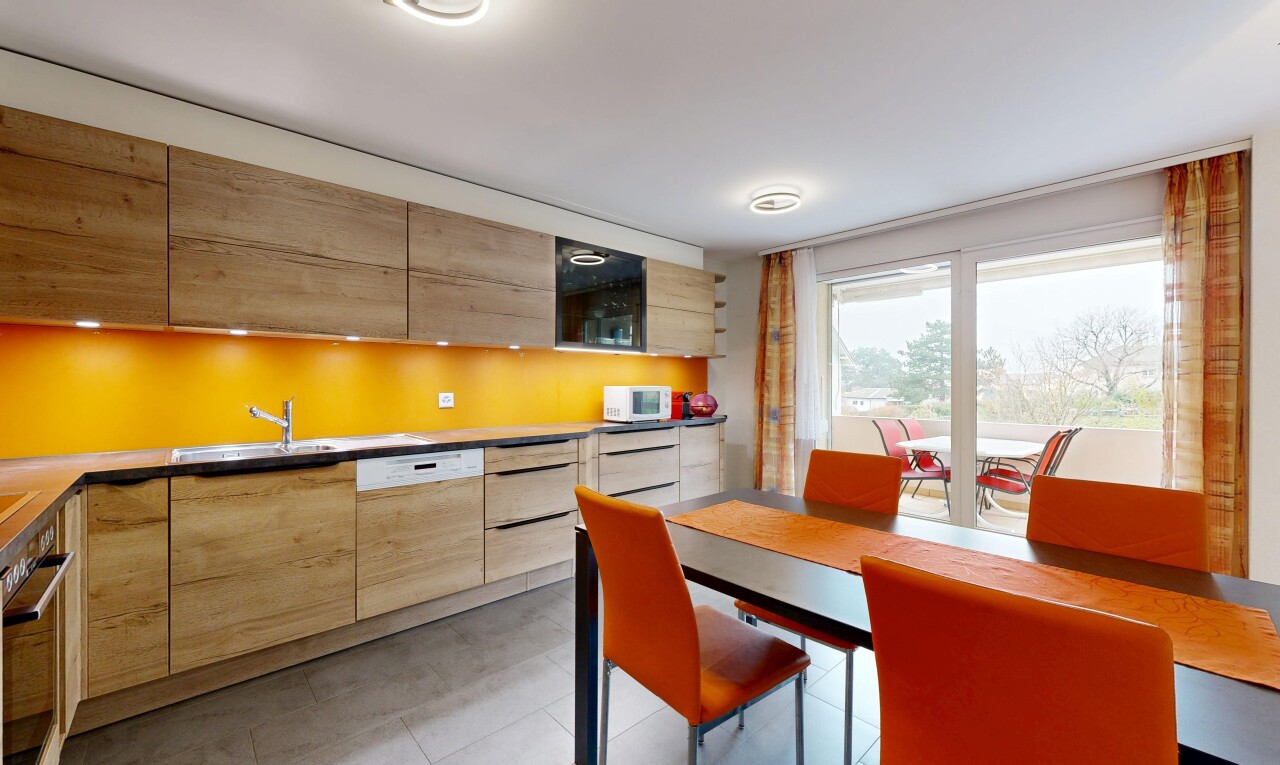 kitchen with modern cabinets, light brown cabinets, and white appliances