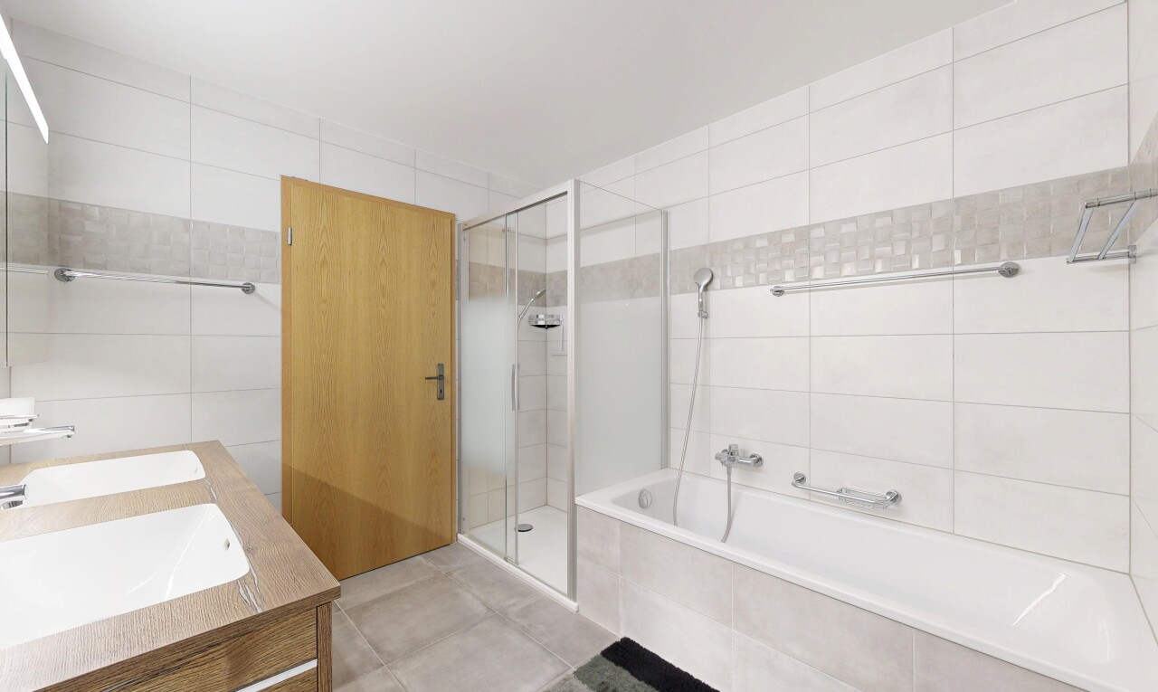 full bath with a stall shower, tile walls, a bath, double vanity, and tile patterned flooring