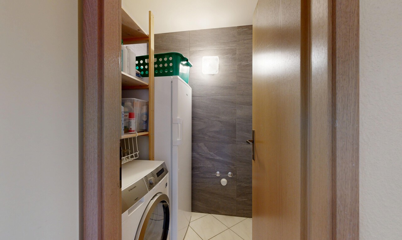 laundry room with washer / dryer, light tile patterned floors, and tile walls