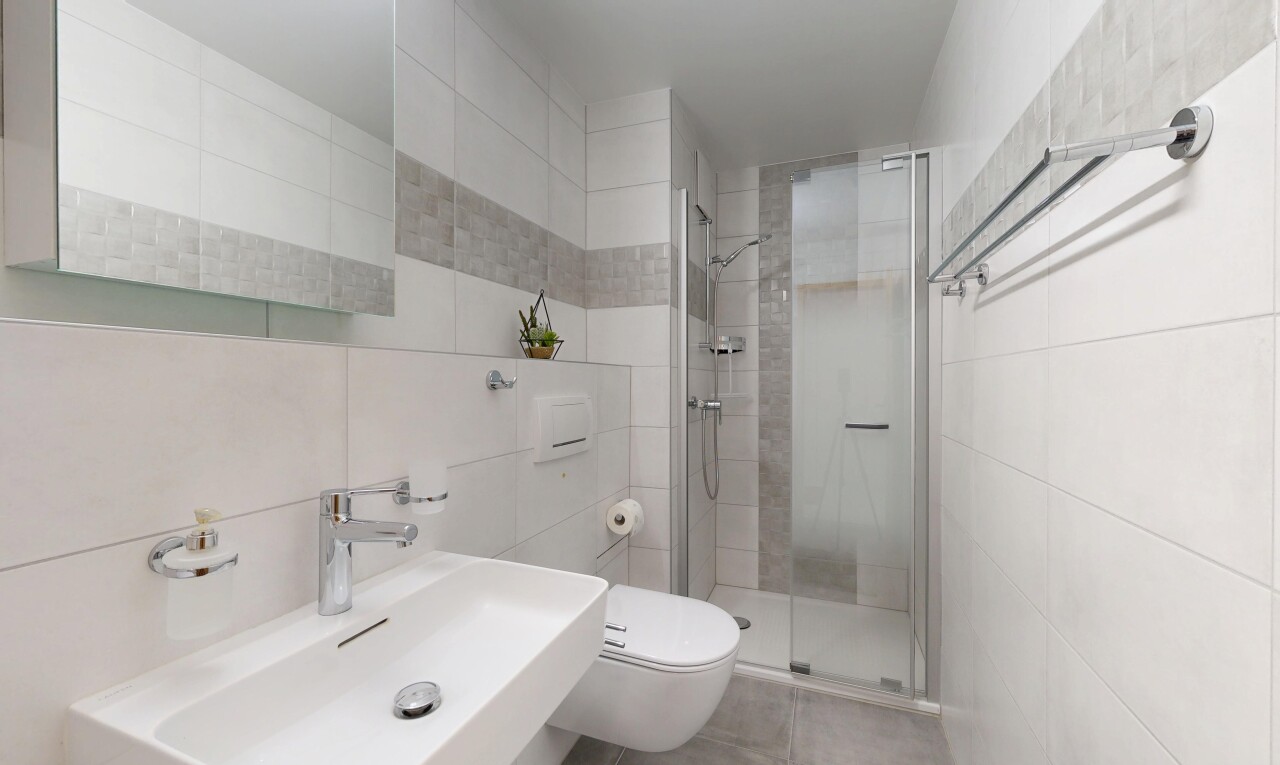bathroom featuring tile walls and a stall shower