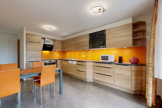 kitchen featuring modern cabinets, open shelves, light brown cabinetry, range hood, and white microwave