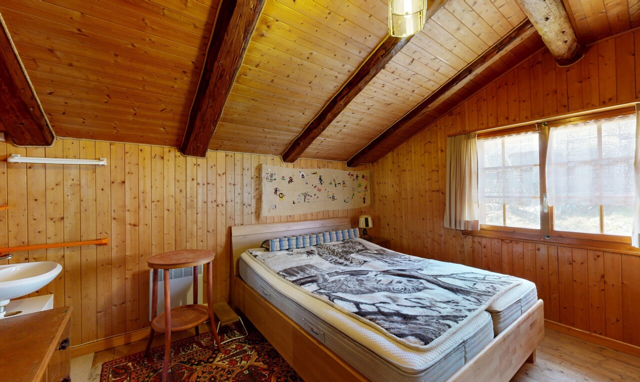 chambre avec beamed ceiling, plafond à poutres, wood wall, mur en bois, et inside property