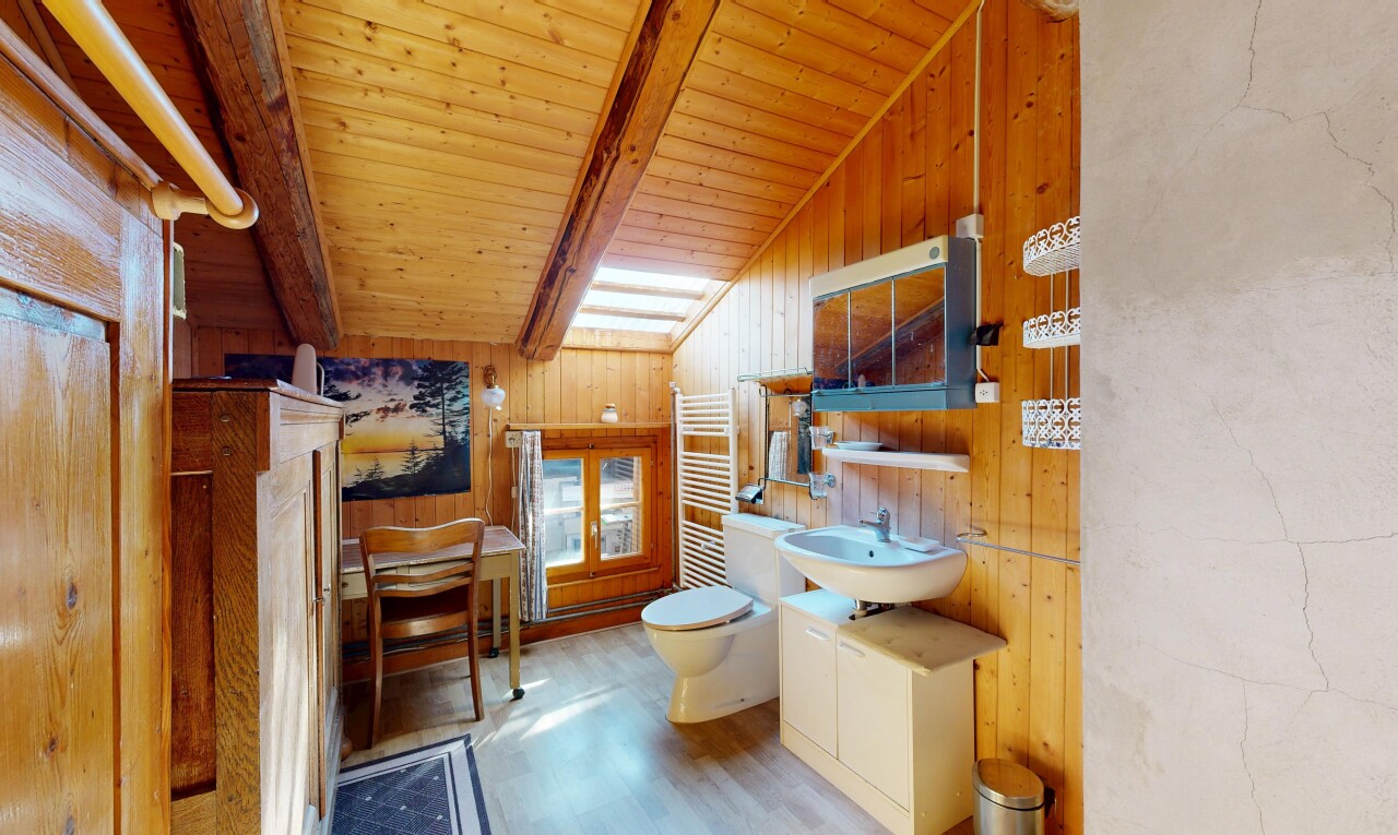 salle de bains avec miroir, chauffe-serviettes, évier, sol en finition bois, et wood finish floor